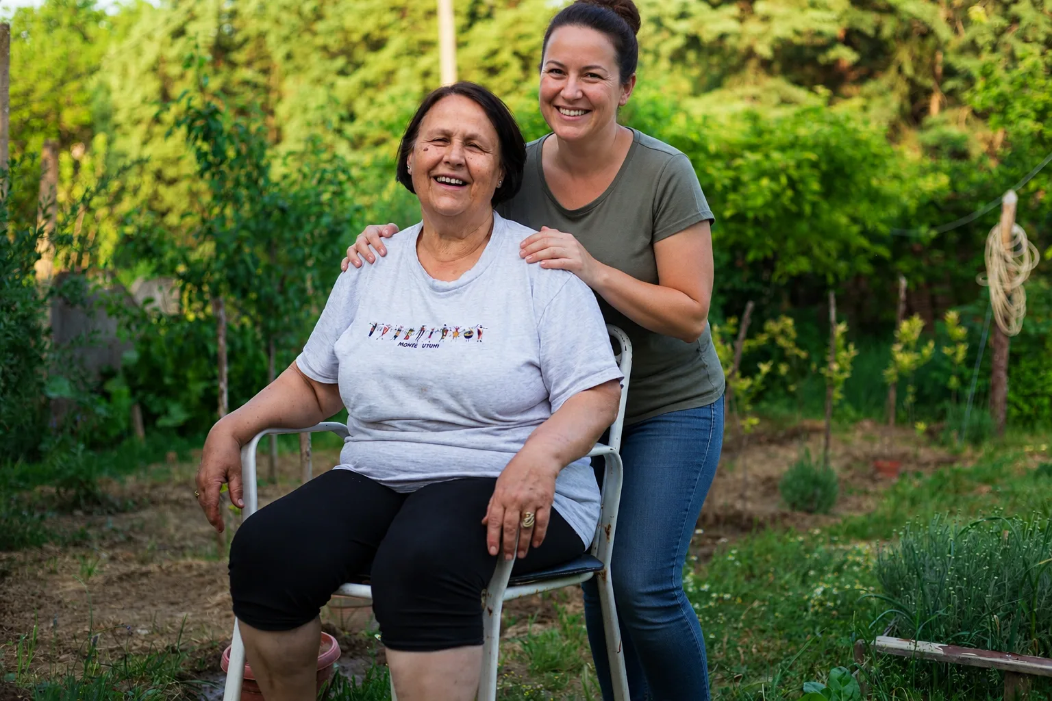 Seniorka z opiekunką w ogrodzie - opieka po zawale